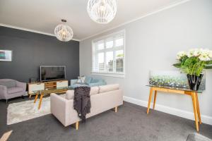 a living room with a couch and a tv at Bolton Street Cottage in Lower Hutt