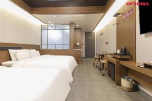 a hotel room with a large bed and a kitchen at Jinju KAI Tourist Hotel in Jinju