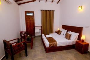 a bedroom with a bed and a desk and a chair at Ayana Resort Wilpattu in Wilpattu