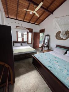 a bedroom with two beds and a wooden ceiling at Royal Resort in Weligama