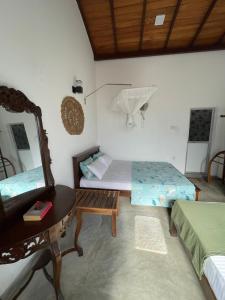 a bedroom with a bed and a mirror and a table at Royal Resort in Weligama