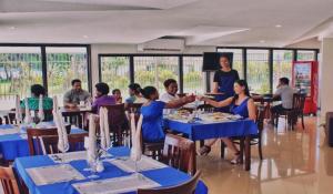 a group of people sitting at tables in a restaurant at Nambis Inn in Madang