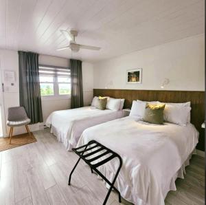 a hotel room with two beds and a chair at En Route Vers l'Infini in Perce