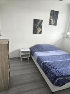 a bedroom with a bed and a night stand at Le Stud in Belfort