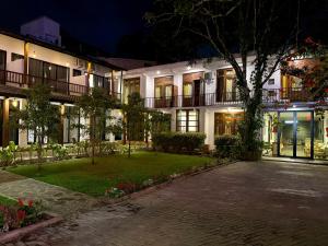 a large building with a courtyard at night at Ella Inn in Ella