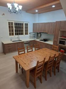 a large kitchen with a wooden table and chairs at Lan Cheng Su in Yuanshan