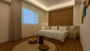 a bedroom with a bed and a table in a room at Lan Cheng Su in Yuanshan