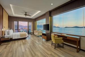 a hotel room with a bed and a large window at Two Seasons Coron Bayside Hotel in Coron