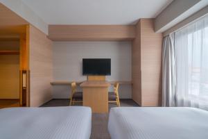a room with two beds and a flat screen tv at Hotel Resol Trinity Hakata in Fukuoka +65 photos