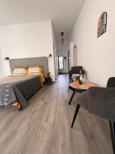 a bedroom with a bed and a table in a room at ATÈRLA - Appartement de charme et SPA privée in La Possession