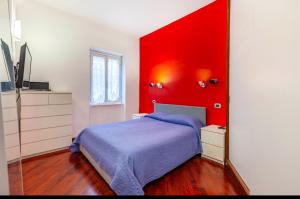 a bedroom with a bed with a red wall at Vacanze Romane con giardino in Rome