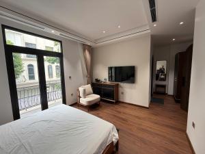 a bedroom with a bed and a television and a chair at MoonLight Homestay in Hòa Bình