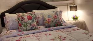a bedroom with a bed with floral pillows at Village Homestay in Udon Thani