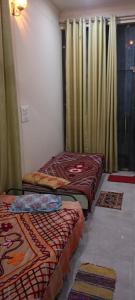 three beds sitting in a room with curtains at Meena Sadan in Prayagraj