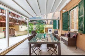 an outdoor patio with a glass table and chairs at Vacanze Romane con giardino in Rome