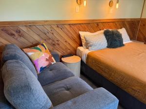a living room with a couch and a bed at Te Anau Lakefront Backpackers in Te Anau