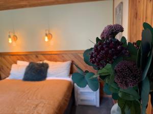 a bedroom with two beds and a vase with flowers at Te Anau Lakefront Backpackers in Te Anau