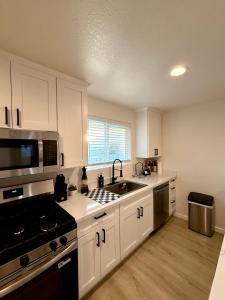 a kitchen with white cabinets and a stove top oven at Beach Paradise- 4 Min Walk To Beach in Santa Cruz +28 photos