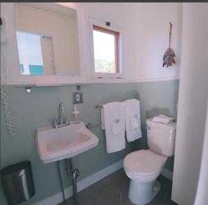 a bathroom with a white toilet and a sink at En Route Vers l'Infini in Perce +6 photos