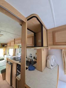 a small kitchen in an rv with a sink and a stove at TheBoxCaravan in Ban Pak Ram