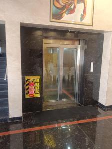 an elevator in a building with a sign on it at VGN Convention Centre in Vāniyambādi