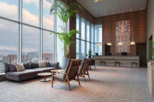 a living room with a couch and a piano at Hotel Resol Trinity Hakata in Fukuoka