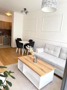 a living room with a white couch and a table at Apartman Vista Banja Luka in Banja Luka
