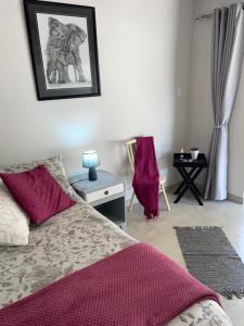a bedroom with a bed and a table with a lamp at Shady Seringa Accommodation in Vanderbijlpark +27 photos