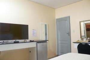 a room with a flat screen tv on a desk at Mamli Guestlodge & Conferencing in Schoemansdal