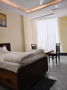 a bedroom with a bed and a table and chairs at RSR event service in Faridabad