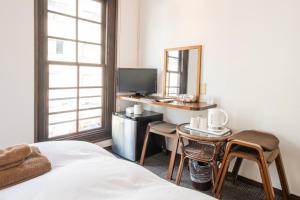 a bedroom with a bed and a desk and a mirror at 開港庵 in Hakodate