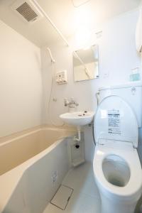 a white bathroom with a toilet and a sink at 開港庵 in Hakodate +60 photos