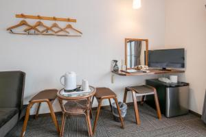 a room with a table and chairs and a mirror at 開港庵 in Hakodate
