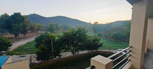 a balcony of a house with a view of a field at The Jungle Gate Villa in Udaipur +50 photos