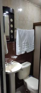 a bathroom with a white toilet and a sink at Casa tabachin in Arandas