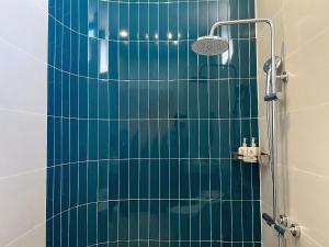 a bathroom with a shower with green tile at Santonita Hotel & Tours in Ninh Hải