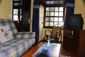 a living room with a couch and a tv at Casa Asuncion in Breña Alta