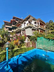 a house with a swimming pool in front of a house at Aurora Farmstay in Rongli