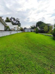 a large grassy yard with houses in the background at D Royale Tapos Resort Bogor in Tapos +13 photos