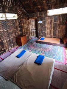 a room with two beds in a straw hut at D Royale Tapos Resort Bogor in Tapos