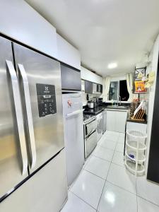 a kitchen with stainless steel appliances and white tile floors at 4 quartos Folia de Olinda in Olinda