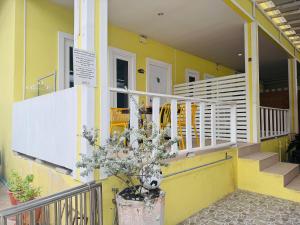 a yellow building with stairs and a potted plant at Baan Ta Long Beach Koh Larn in Ko Larn