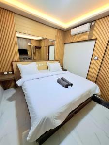 a bedroom with a large white bed with a towel on it at 7 Day Inn in Gili Trawangan
