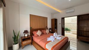 a bedroom with a bed with a bow on it at Emstaliese & Palmarosa Villas Seminyak in Legian +41 photos