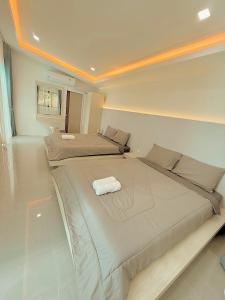 a bedroom with two beds in a room at Chaisona at Khanom Cottage in Ban Phaeng