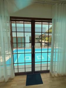 a view of a swimming pool through a sliding glass door at Chaisona at Khanom Cottage in Ban Phaeng