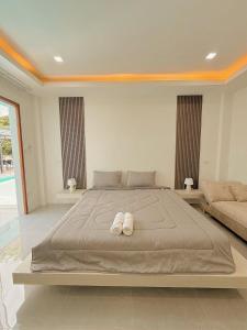 a bedroom with a large bed with two white towels at Chaisona at Khanom Cottage in Ban Phaeng