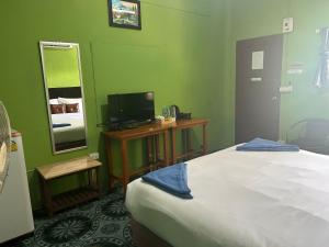 a bedroom with a bed and a tv and a mirror at ABC Bungalow in Ban Tai