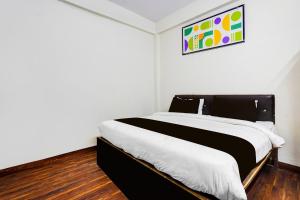 a bedroom with a black and white bed in a room at Hotel O George Town in Colonelganj
