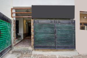 a metal garage door with a sign on top of it at Hotel O George Town in Colonelganj